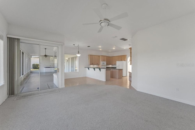 unfurnished living room featuring ceiling fan and light colored carpet