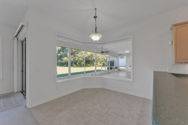 unfurnished dining area with light tile patterned floors and ceiling fan