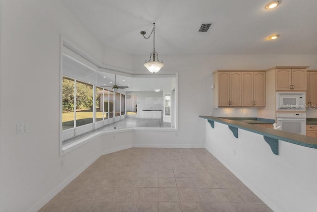 kitchen featuring ceiling fan, light brown cabinets, pendant lighting, white appliances, and light tile patterned flooring