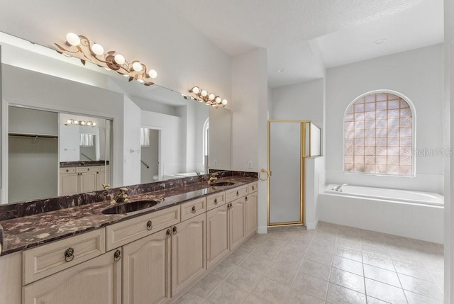 bathroom with tile patterned floors, vanity, shower with separate bathtub, and a textured ceiling