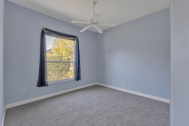 carpeted spare room featuring ceiling fan