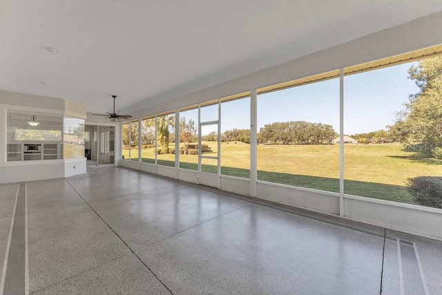 unfurnished sunroom with ceiling fan