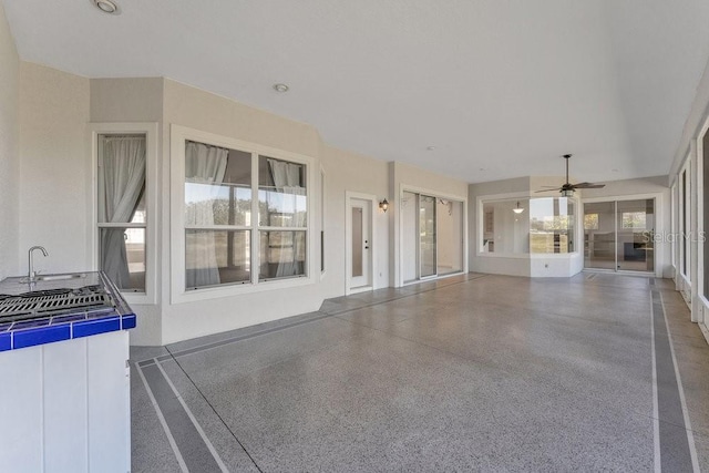 unfurnished living room with ceiling fan