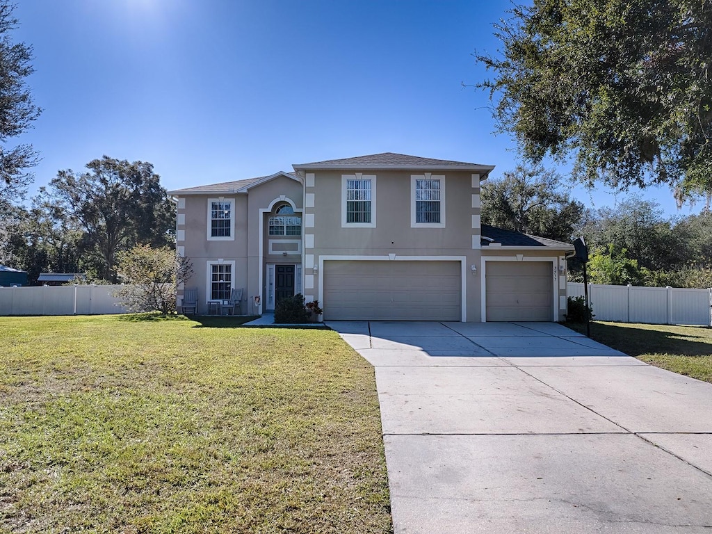 view of property featuring a front yard and a garage