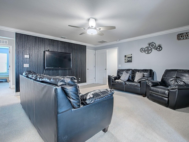 living room with a textured ceiling, ceiling fan, light colored carpet, and crown molding