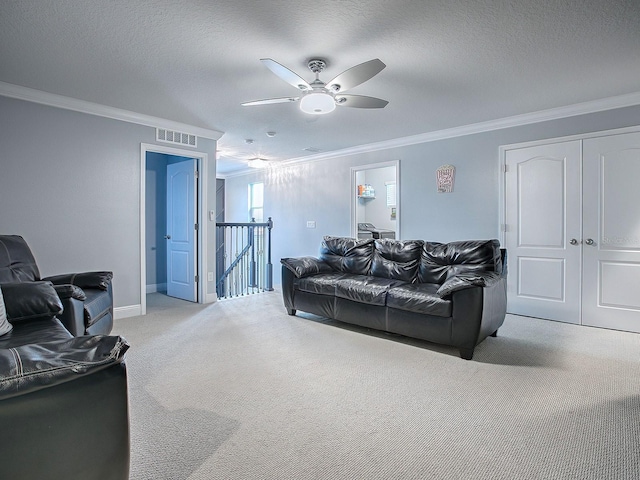 carpeted living room with crown molding, ceiling fan, and a textured ceiling