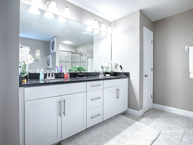 bathroom with vanity, an enclosed shower, and a textured ceiling