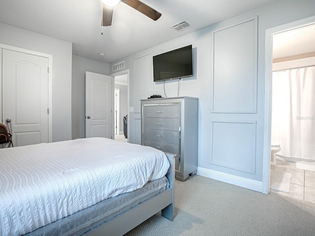 bedroom featuring connected bathroom, ceiling fan, and light colored carpet