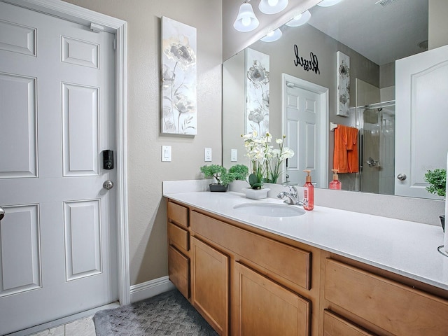 bathroom with tile patterned floors, vanity, and a shower with door