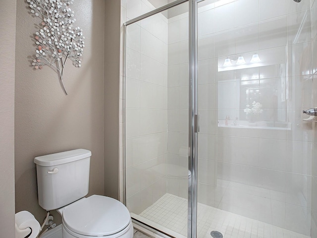 bathroom with toilet and a shower with shower door