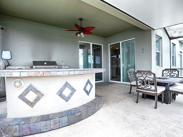 view of patio with an outdoor kitchen, ceiling fan, and area for grilling