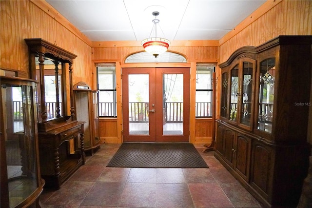 entryway with french doors, wooden walls, and plenty of natural light