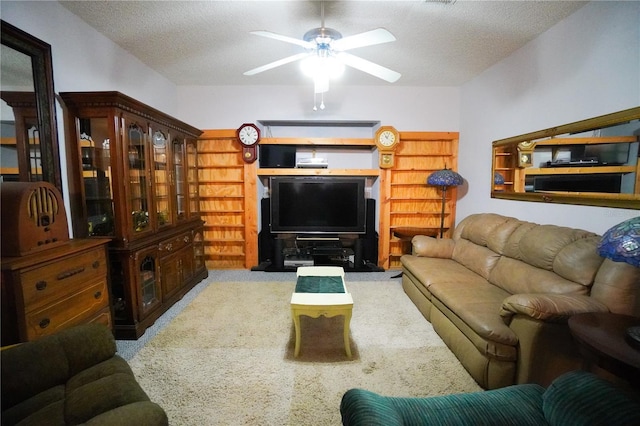 living room with a textured ceiling, ceiling fan, and light carpet