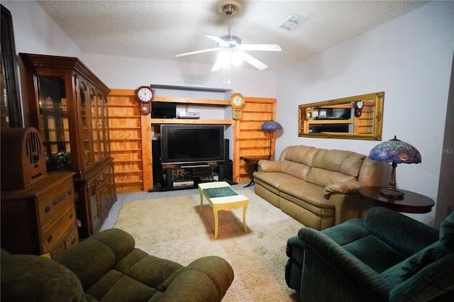 living room with a textured ceiling, ceiling fan, and carpet flooring