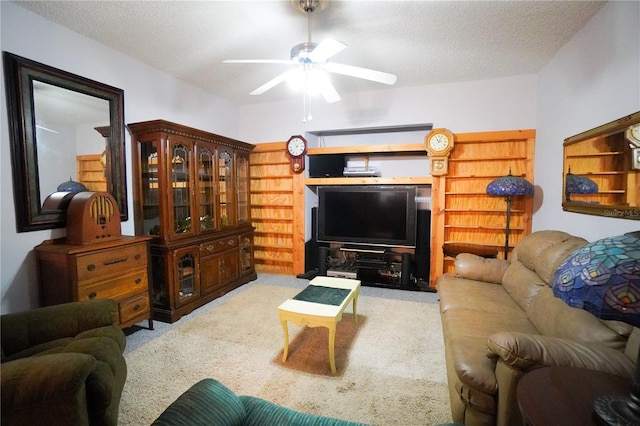 carpeted living room with a textured ceiling and ceiling fan