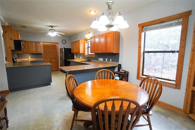 dining room featuring sink and ceiling fan with notable chandelier