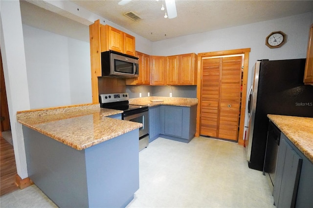 kitchen with appliances with stainless steel finishes, ceiling fan, kitchen peninsula, and light stone countertops