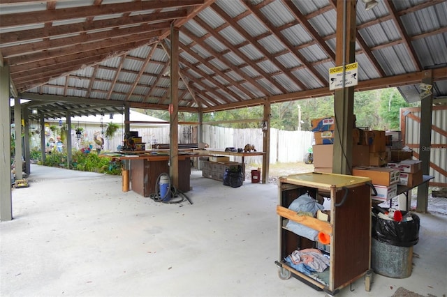 exterior space with high vaulted ceiling, concrete flooring, and a workshop area