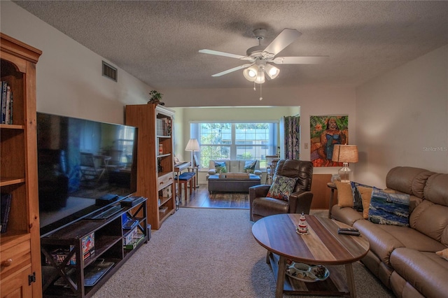 living room featuring ceiling fan, a textured ceiling, and hardwood / wood-style flooring