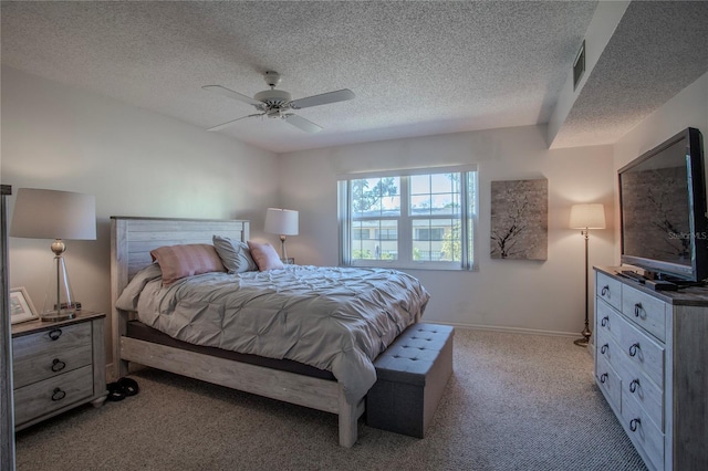 bedroom featuring a textured ceiling, light colored carpet, and ceiling fan