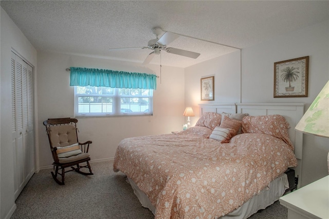 carpeted bedroom with ceiling fan, a closet, and a textured ceiling