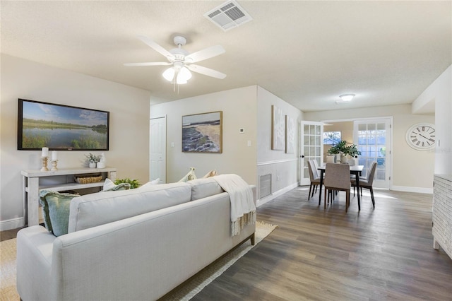 living room with ceiling fan and dark hardwood / wood-style flooring