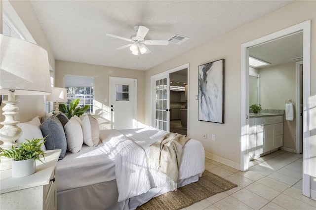 tiled bedroom featuring ceiling fan, a textured ceiling, and connected bathroom