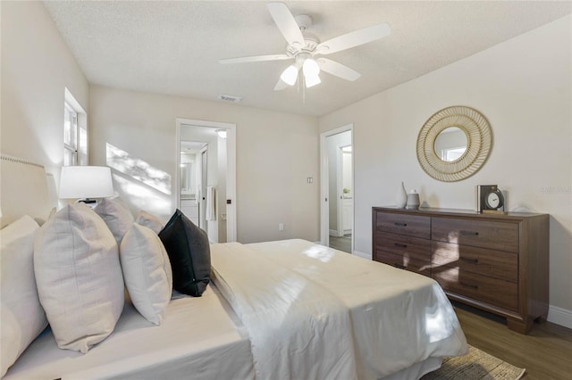 bedroom with hardwood / wood-style floors, ceiling fan, and a textured ceiling