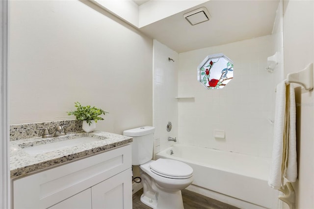 full bathroom with hardwood / wood-style floors, vanity, toilet, and tiled shower / bath combo