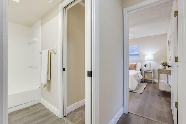 bathroom featuring shower / tub combination, a textured ceiling, and hardwood / wood-style flooring