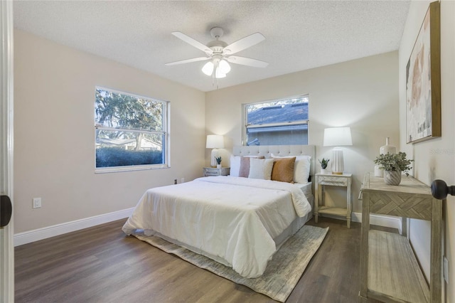 bedroom with a textured ceiling, dark hardwood / wood-style floors, and ceiling fan