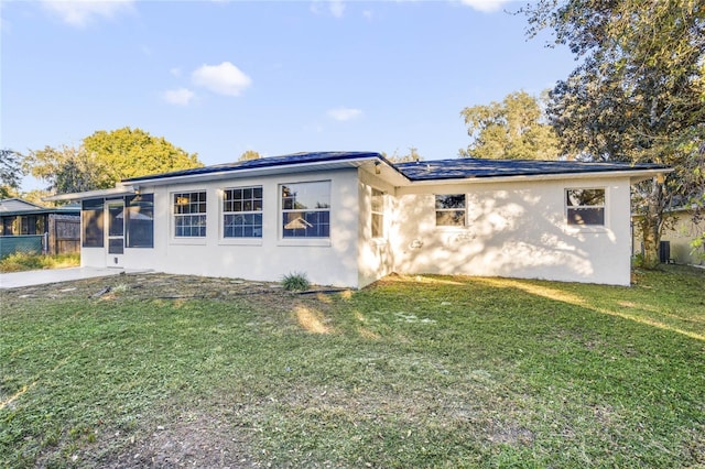 view of front of house with a sunroom and a front yard