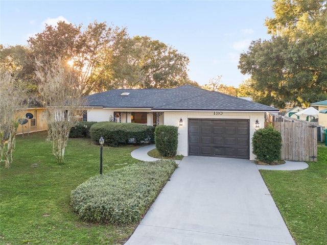 ranch-style home featuring a front lawn and a garage