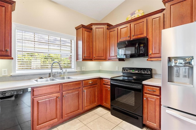 kitchen featuring light tile patterned floors, sink, vaulted ceiling, and black appliances