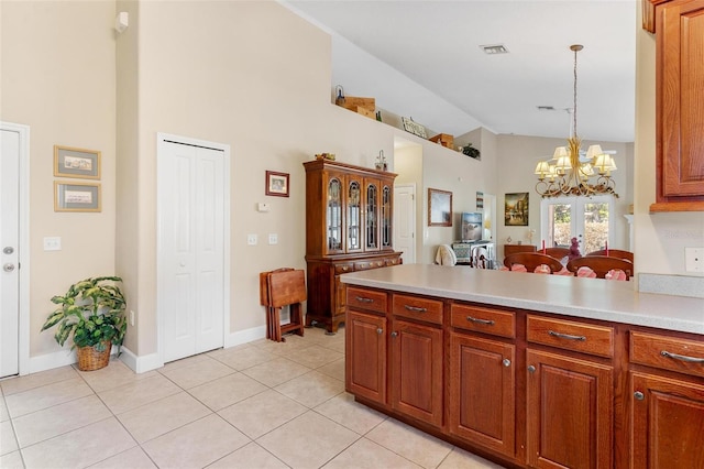 kitchen featuring a notable chandelier, decorative light fixtures, light tile patterned floors, and high vaulted ceiling