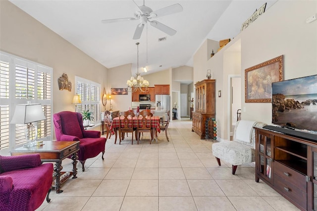 tiled dining space with ceiling fan with notable chandelier and high vaulted ceiling