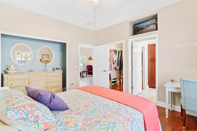 bedroom with a walk in closet, light hardwood / wood-style floors, and a closet