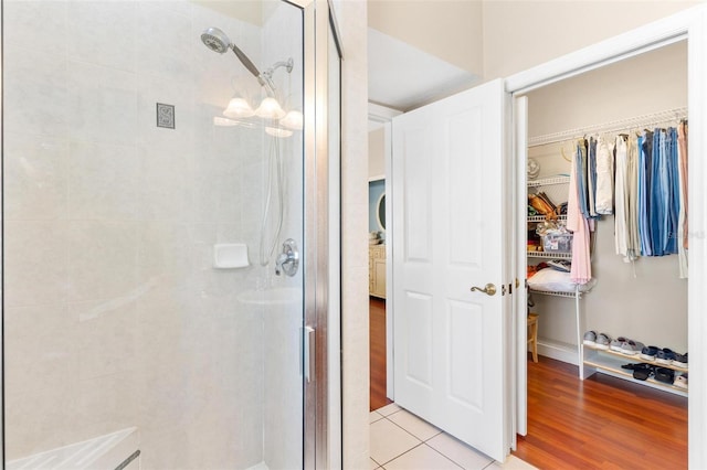 bathroom with hardwood / wood-style floors and a shower with shower door