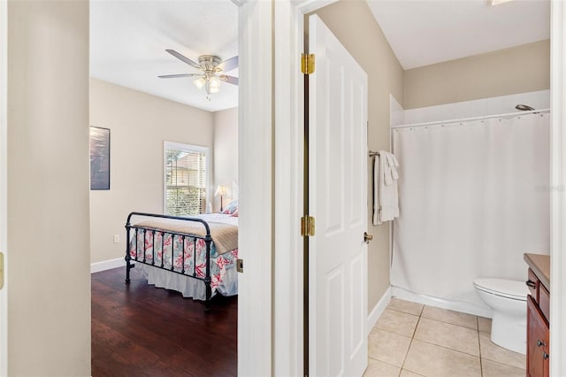 bathroom with curtained shower, ceiling fan, hardwood / wood-style floors, toilet, and vanity