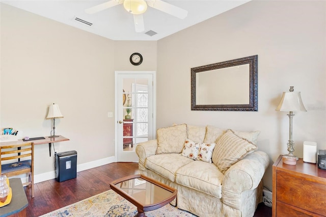 living room featuring ceiling fan and dark wood-type flooring