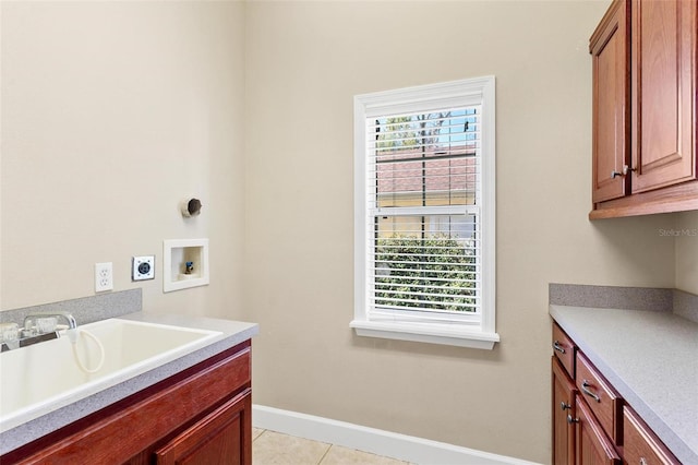 clothes washing area featuring sink, cabinets, hookup for an electric dryer, hookup for a washing machine, and light tile patterned floors