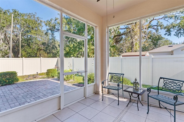 unfurnished sunroom featuring ceiling fan