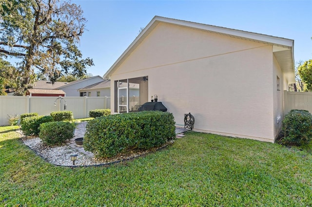 view of property exterior featuring a lawn and a sunroom