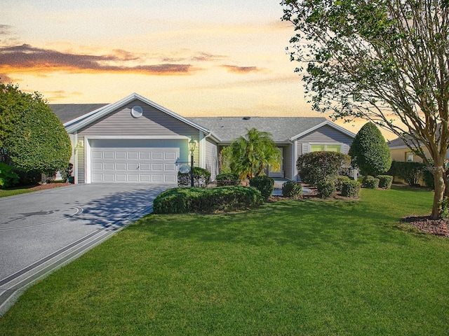 ranch-style house featuring a lawn and a garage