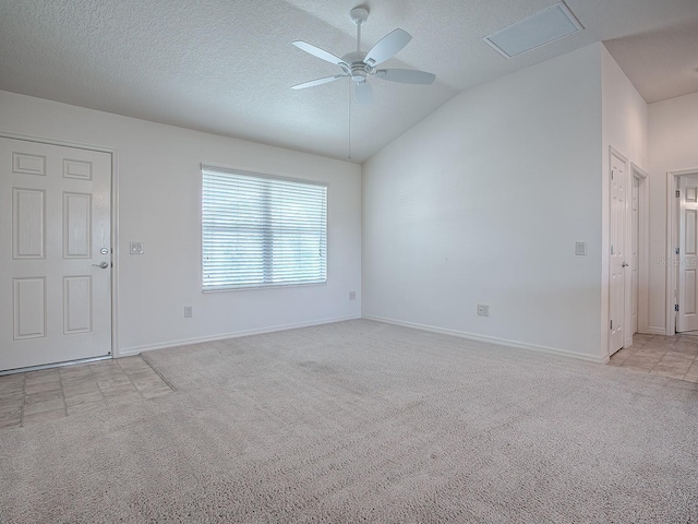 spare room with a textured ceiling, ceiling fan, lofted ceiling, and light carpet