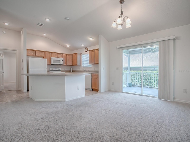 kitchen with lofted ceiling, white appliances, hanging light fixtures, and a wealth of natural light