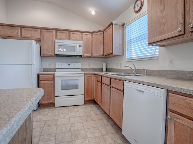 kitchen with lofted ceiling, white appliances, and sink