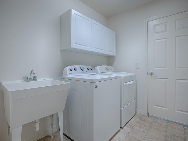 laundry area featuring sink, cabinets, and independent washer and dryer