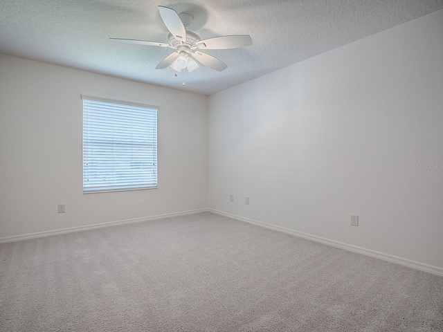 carpeted spare room featuring ceiling fan and a textured ceiling