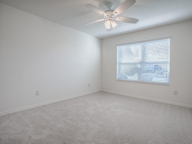 spare room featuring ceiling fan, carpet, and a textured ceiling